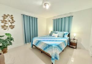 a bedroom with a bed with blue curtains and a plant at Miami Blue Oasis l 2BR with free parking in Miami +47 photos