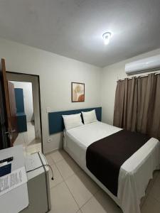 a hotel room with a bed and a desk and a bed sidx sidx at Pousada Caribe Brasileiro in Maragogi