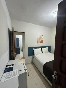a bedroom with a bed and a desk in it at Pousada Caribe Brasileiro in Maragogi