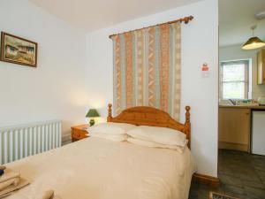 a bedroom with a large bed with white sheets at Apartment 4 in North Lydbury