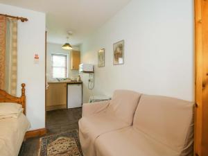 a living room with a couch and a kitchen at Apartment 4 in North Lydbury