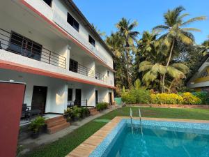 a resort with a swimming pool next to a building at Shree Krishna Sudha Resort in Alibaug