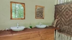 two sinks on a wooden counter in a bathroom at SELAYAR TURTLE BAY in Barangbarang