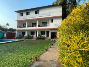 a building with a pool in front of it at Shree Krishna Sudha Resort in Alibaug