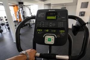 a person in a gym with a phone on a machine at Hotel Boutique Mura in Cancún