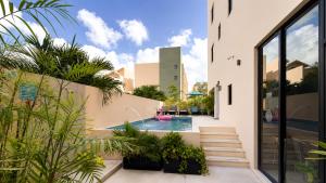 a courtyard with a swimming pool and plants at Hotel Boutique Mura in Cancún