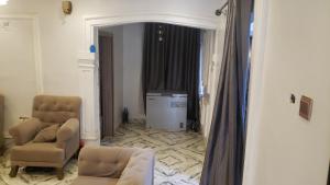 a living room with a couch and two chairs and a television at Sejeva in Ikorodu