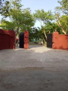 a parking lot with trees and red brick walls at Royal Heritage Lodges in Bahawalpur