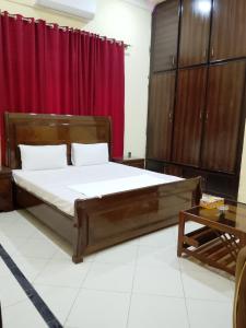 a bedroom with a large bed and a red curtain at Royal Heritage Lodges in Bahawalpur
