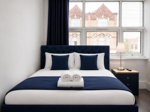 a bedroom with a bed with two towels on it at The Broadway Hotel - London Heathrow in Southall