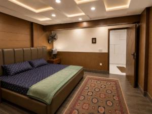 a bedroom with a bed and a door with a rug at Cecil Apartments On Mall Road Murree in Murree