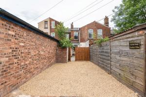 an alley with a brick wall and a gate at Gordan Villas in Leigh +8 photos