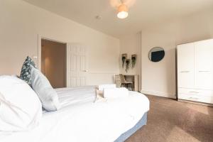 a white bedroom with a large bed and a desk at Gordan Villas in Leigh