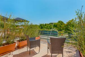 two chairs sitting on a patio with plants at Hotel Sole in Marina di Massa