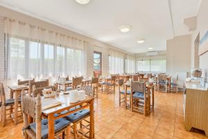 a dining room with tables and chairs and windows at Hotel Sole in Marina di Massa