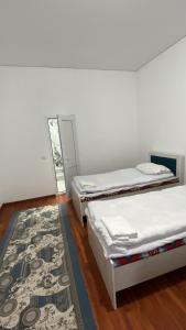 two beds in a room with a rug at Amir in Arkit