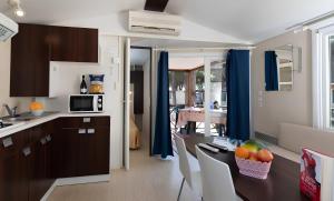 a kitchen with a table with a bowl of fruit on it at Camping Pineta - Nikoli Tour in Cesenatico