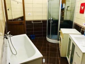 a bathroom with a tub and two sinks and a shower at Dyrrah Rooms Central in Durrës