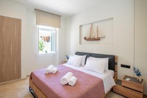 a bedroom with a large bed with white towels on it at MARIA'S Roof Top View in Poros