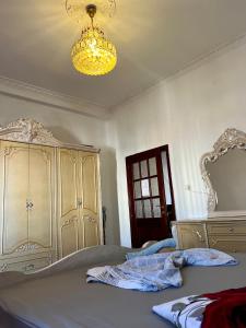 a bedroom with a large bed and a chandelier at Dyrrah Rooms Central in Durrës