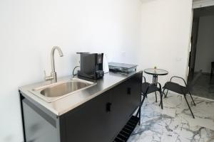 a kitchen with a sink and a table with chairs at B&B Francy and sons in Modugno +77 photos