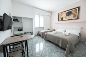 a bedroom with two beds and a table and a desk at B&B Francy and sons in Modugno