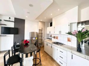a kitchen with white cabinets and a table with chairs at Departamento 2B 3 dormitorios, 2A 2 dormitorios in Manta