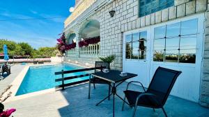 a patio with a table and chairs next to a pool at Marevista in Dramalj