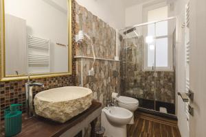 a bathroom with a sink and a toilet and a mirror at Trieste Centro Rooms-camere eleganti in pieno centro in Trieste