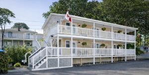 a white house with a flag on it at Blue Shutters Inn and Studios in Ogunquit