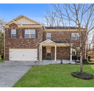 a brick house with a garage and a tree at Luxury Room In McDonough in McDonough