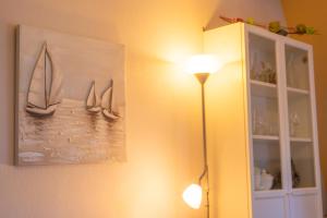 a lamp next to a painting of boats on the wall at Bright Apartment in Haapsalu in Haapsalu