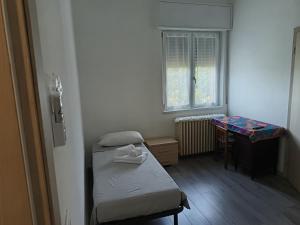 a small room with a bed and a table and a window at B&B Villa AVE in Seriate