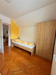 a bedroom with a bed and a wooden cabinet at Apartmaji Tomšič in Mojstrana