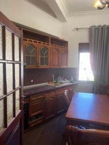 a kitchen with wooden cabinets and a table and a window at Dyrrah Rooms Central in Durrës