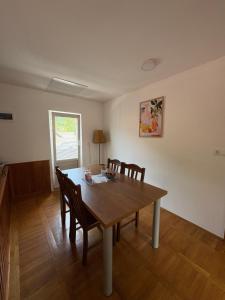 a dining room with a wooden table and chairs at Apartmaji Tomšič in Mojstrana