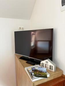 a flat screen tv sitting on top of a wooden table at Apartmaji Tomšič in Mojstrana