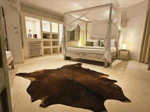 a large bedroom with a bed with a large rug in the floor at The Villa Luxury Suites Hotel in Diani Beach
