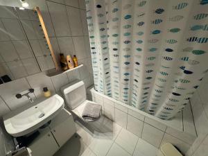 a bathroom with a sink and a toilet and a shower curtain at Blue Ocean in Göschenen +15 photos