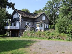 an old house with a porch and a balcony at Riverside Landhaus-Villa und Lodge XXL Garten bis 24 Personen in Mittelhof