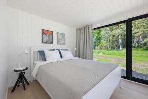 a bedroom with a bed and a large window at Kasispea Meremaja in Kasispea