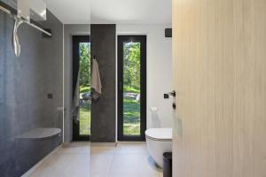 a bathroom with a toilet and a sink and glass doors at Kasispea Meremaja in Kasispea
