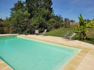 a swimming pool with three lounge chairs in a yard at Tente Zéla in Ambillou-Château