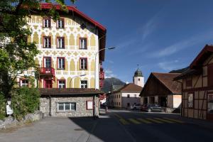 a yellow and white building on the side of a street at Hotel Pianta in Savognin +6 photos