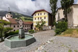 a fountain in the middle of a town with buildings at Hotel Pianta in Savognin