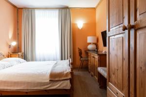 a bedroom with a bed and a window at Hotel Pianta in Savognin