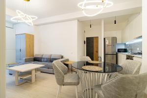 a kitchen and a living room with a table and chairs at Stylish 2BR Apartment in Yerevan in Yerevan +14 photos