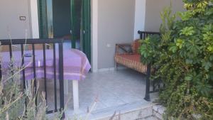 a porch with a bench with a blanket on it at Ground floor economy studio in karmiris studios in Zakynthos +5 photos