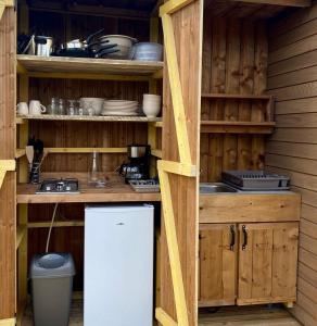 a kitchen with wooden cabinets and a white refrigerator at Tente Zéla in Ambillou-Château