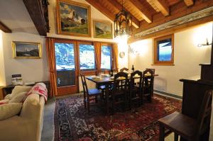 a living room with a table and chairs and a couch at Haus Tiefbach - Apartment Cervino in Zermatt